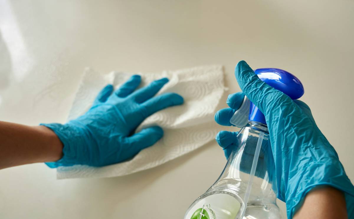 how to clean reusable cleaning gloves shown with vinegar soak and hanging to dry