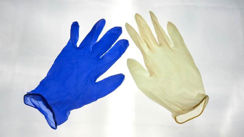Close-up of eco-friendly reusable gloves on a wooden kitchen counter with fresh produce nearby