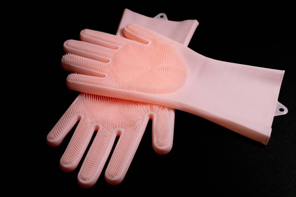 elgood reusable dishwashing cleaning gloves being used to wash dishes in a stainless steel sink with suds and citrus peels nearby