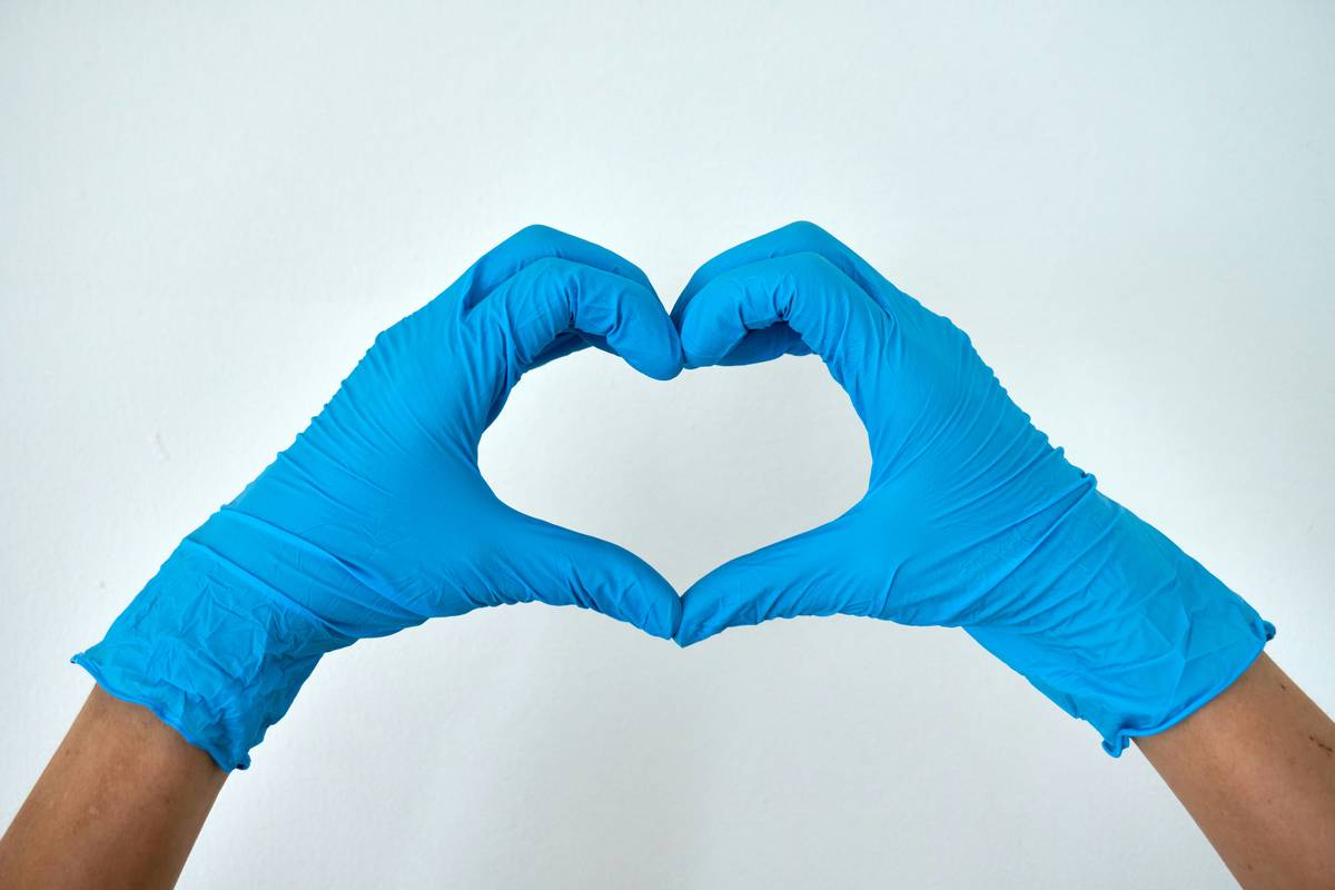 Close-up of worn chemical resistant work gloves handling cleaning supplies in a sustainable kitchen
