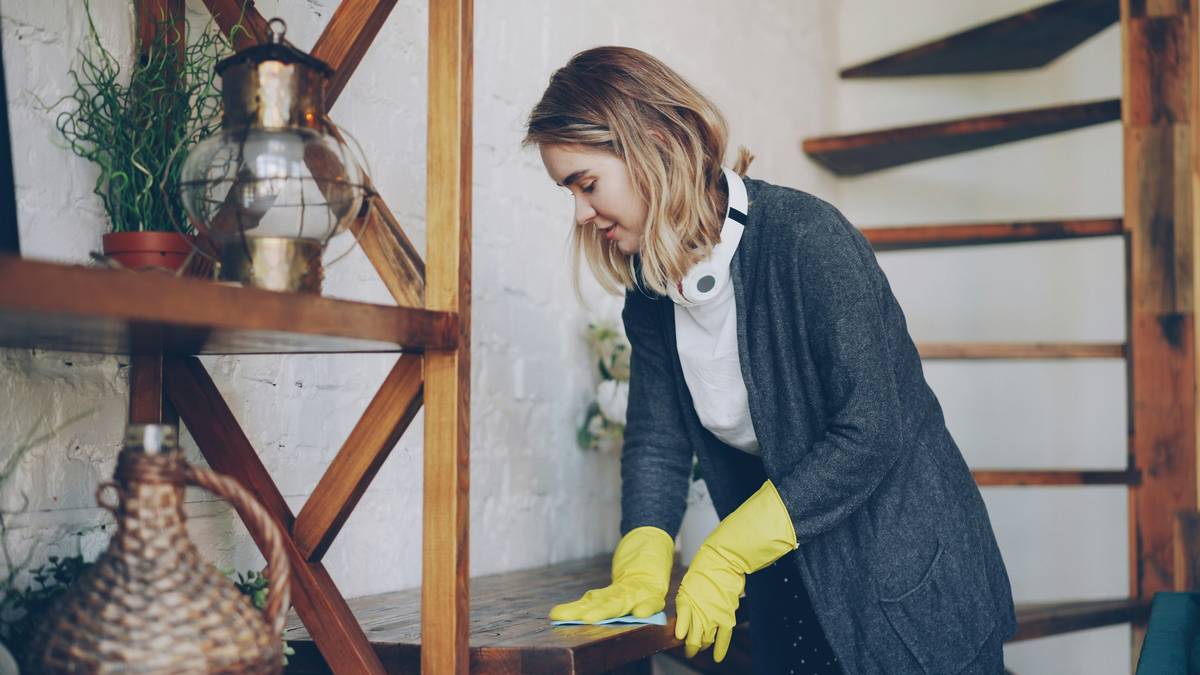 how to clean reusable rubber gloves: hands holding freshly cleaned rubber gloves under running water